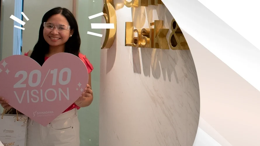 Happy woman holding a heart-shaped sign that says ‘20/10 Vision’ after LASIK surgery at Shinagawa Lasik & Aesthetics Center