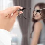 View through eyeglasses showing a sharp image of a woman in front, with the surrounding vision blurred—illustrating the clarity provided by corrective lenses