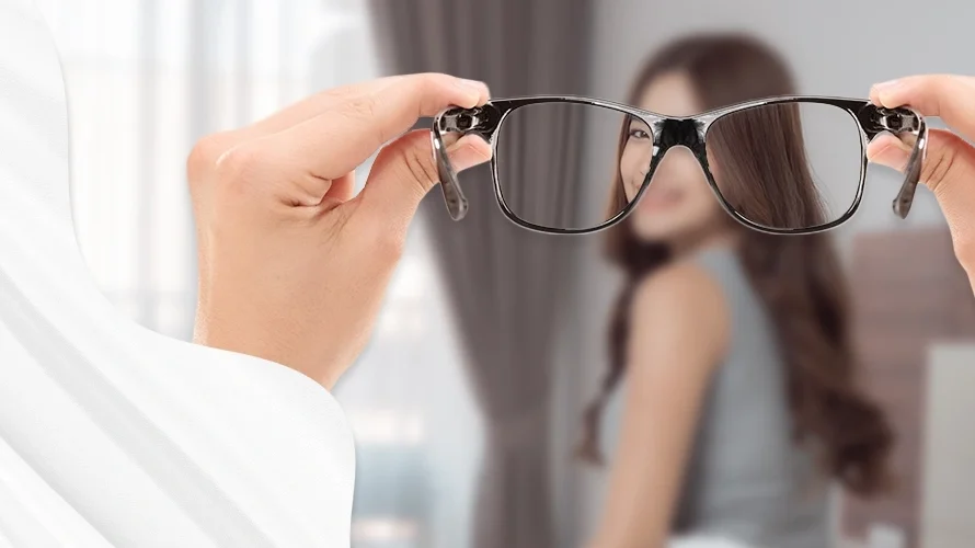 View through eyeglasses showing a sharp image of a woman in front, with the surrounding vision blurred—illustrating the clarity provided by corrective lenses