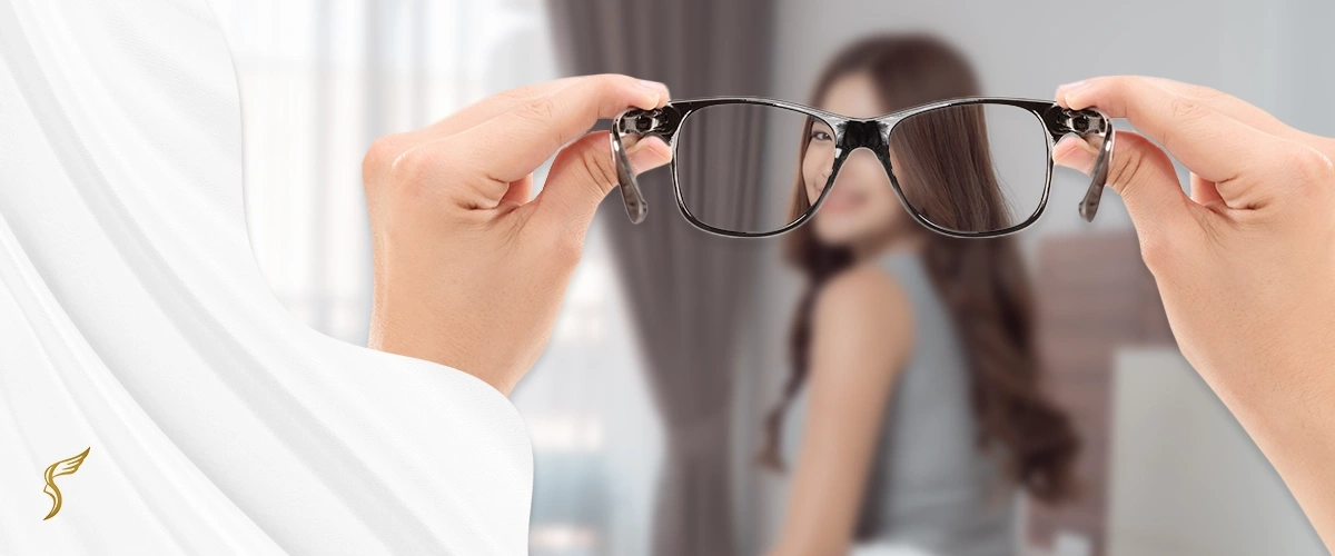 View through eyeglasses showing a sharp image of a woman in front, with the surrounding vision blurred—illustrating the clarity provided by corrective lenses