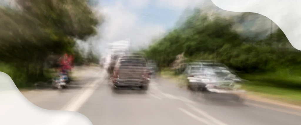 Blurry view of a road and vehicles simulating distorted vision caused by conditions like astigmatism or uncorrected refractive errors