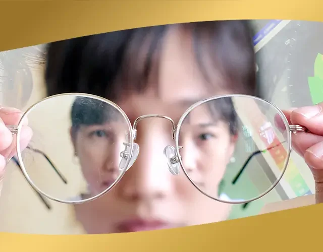 Close-up of person holding eyeglasses with blurred reflection, highlighting vision problems before LASIK at Shinagawa Lasik & Aesthetics Philippines