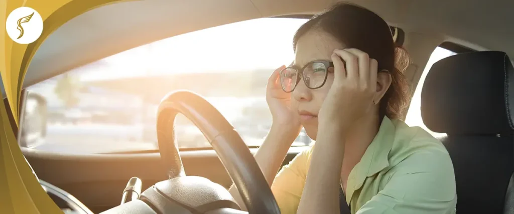 Woman wearing glasses struggles to see clearly while driving in bright sunlight, illustrating vision problems and need for LASIK at Shinagawa Philippines