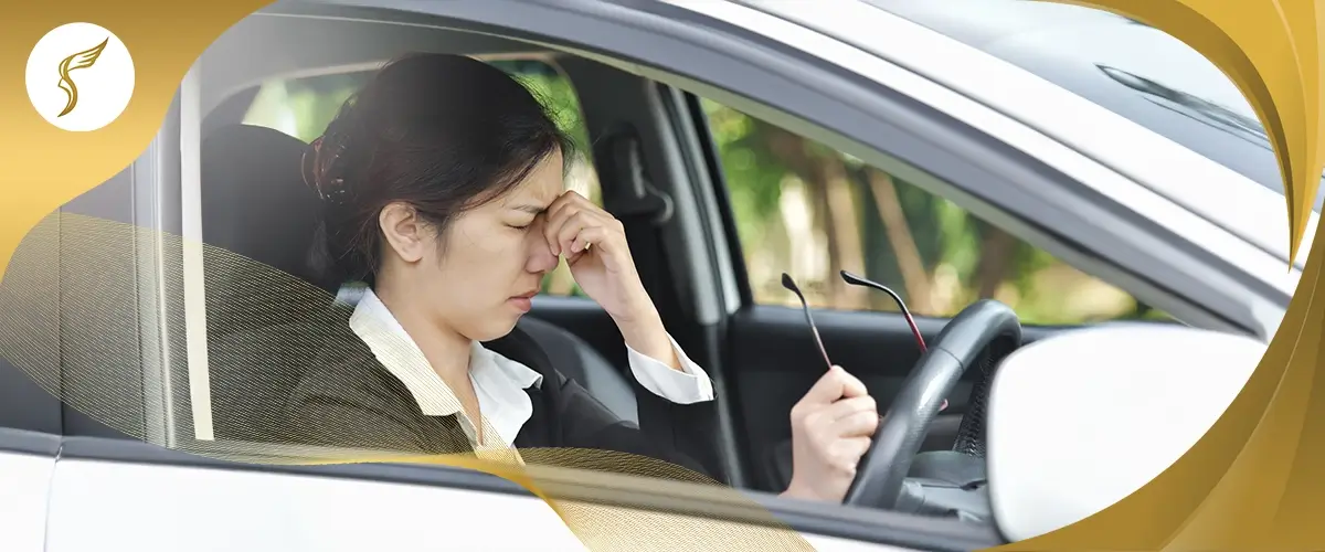 Woman sitting in a car rubbing her eyes from blurry vision or eye strain, suggesting possible keratoconus or vision issues while driving