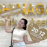 Patient celebrating successful LASIK surgery at Shinagawa Lasik & Aesthetics while holding Perfect Vision and 20/12 Vision signs.