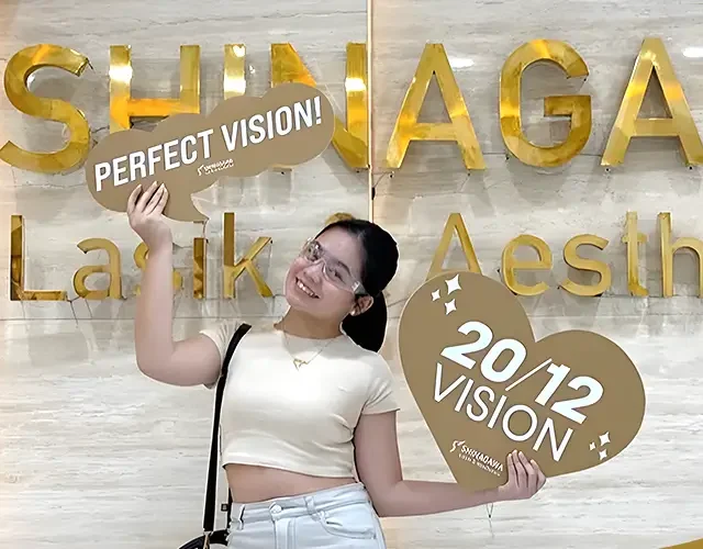 Patient celebrating successful LASIK surgery at Shinagawa Lasik & Aesthetics while holding Perfect Vision and 20/12 Vision signs.