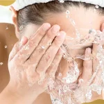 Woman washing her face with water as part of proper eye care and hygiene before and after eye treatments at Shinagawa Lasik & Aesthetics.