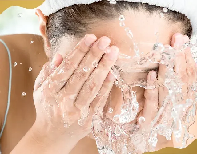 Woman washing her face with water as part of proper eye care and hygiene before and after eye treatments at Shinagawa Lasik & Aesthetics.