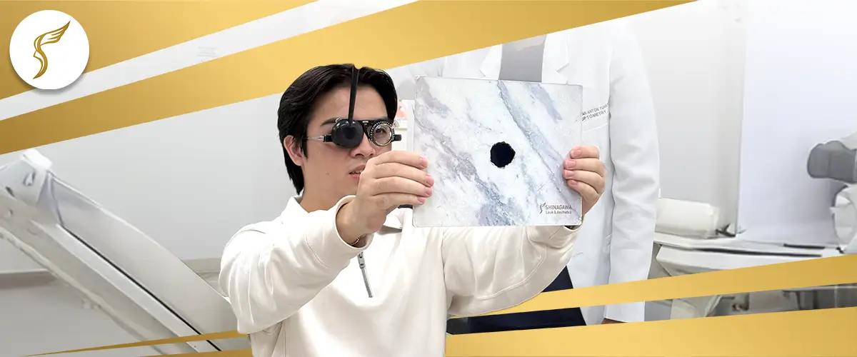 Patient undergoing eye exam at Shinagawa Lasik & Aesthetics using occluder glasses and pinhole test chart to assess visual acuity and refractive errors.