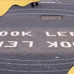 Road marking reading ‘Look Left’ on pedestrian crossing, illustrating visual awareness, directional perception, and road safety cues.