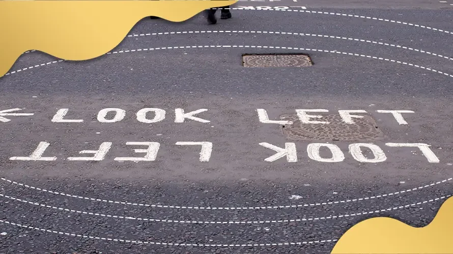 Road marking reading ‘Look Left’ on pedestrian crossing, illustrating visual awareness, directional perception, and road safety cues.